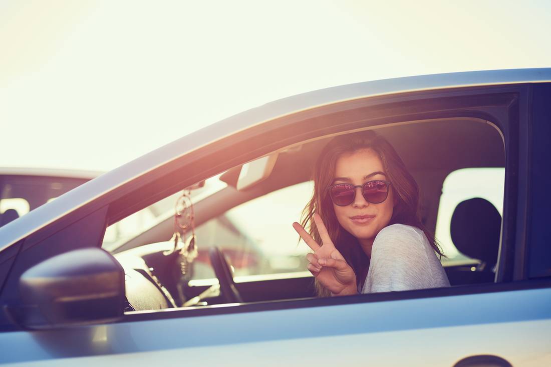 Woman in car with victory sign