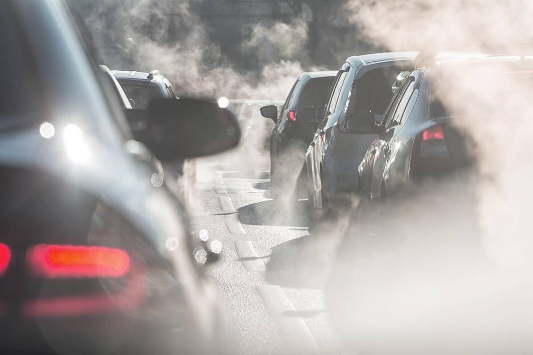 Traffic jam. Blurred silhouettes of cars surrounded by steam from the exhaust pipes